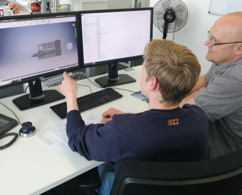 Ein Mitarbeiter der 3D-Micromac bringt einem Schüler im Praktikum 3D-Konstruktion bei. Die perfekte Vorbereitung für ein duales Studium in digital Engineering.