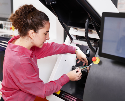 Ein dualer Student lernt eine Laser-Maschine zu bedienen.