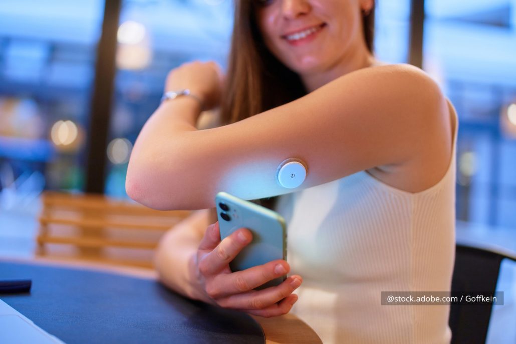 Eine Frau trägt einen Blutzucker-Sensor am Arm.