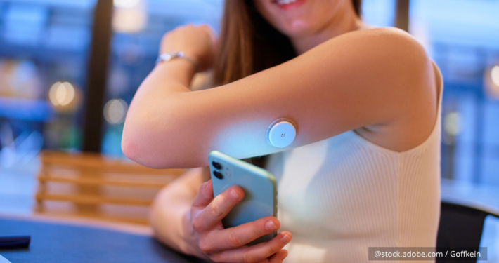 Eine Frau trägt einen Blutzucker-Sensor am Arm.
